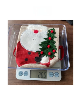 Detailed view of Santa Christmas wine bag on digital scale showing weight of 26.5g
