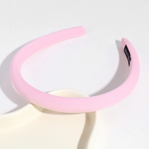 Detail of pink fabric sponge headband with handmade label on a heart-shaped tray