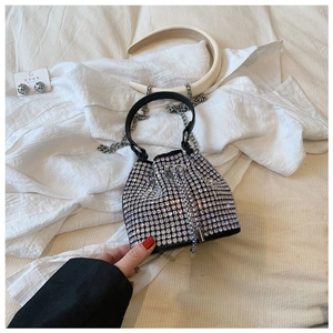 Detailed view of handmade silver rhinestone bucket bag with drawstring closure and metal chain