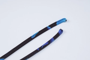 Dettaglio delle spalline incrociate con stampa astratta blu e nera su maglia elastica