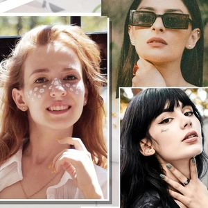 Macro detail of silver heart earrings, black sunglasses, and minimalist ring on model