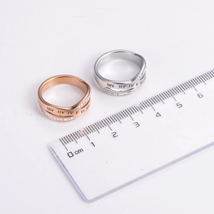 Minimalist Roman numeral rings in rose gold and silver shown with measuring ruler