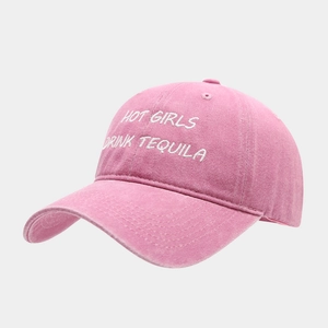 Close-up of pink washed cotton baseball cap with white HOT GIRLS DRINK TEQUILA embroidery