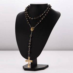 Detail of 8mm black beads rosary necklace with 18K gold plated cross on display stand