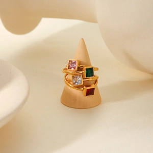 Macro detail of four gold plated steel rings with square colorful zircon stones
