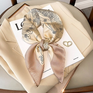 Polka dot silk neck scarf for women styled on a beige blazer with luxury fashion aesthetic