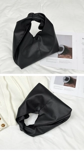 Detailed view of the black pebbled leather texture and knotted handle on a soft hobo bag