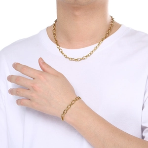 Gros plan d'un ensemble collier et bracelet 7mm en acier inoxydable doré sur un mannequin