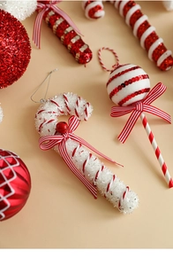 Detail of red and white Christmas candy ornaments with glitter texture and ribbons