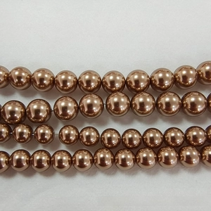Gros plan de quatre rangées de perles en verre marron café avec lustre métallique poli