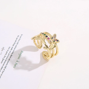 Golden multi-layer wrap ring with colorful butterfly zircons on a vintage paper background