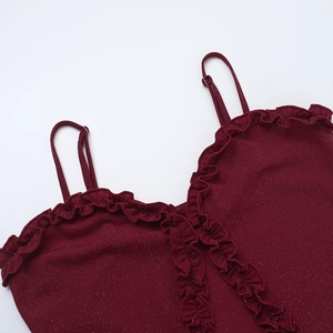 Dettaglio dell'abito glitter bordeaux con spalline sottili e texture con volant