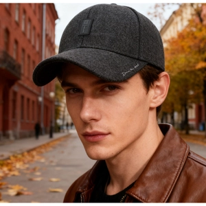 Close-up of a dark grey winter baseball cap with white embroidery on a male model