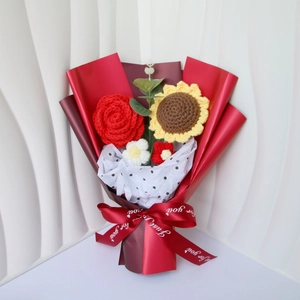 Detail of hand-knitted sunflower and red rose bouquet with Just For You ribbon wrap