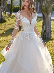 Détail de manches longues en dentelle blanche et col en V sur une robe de mariée vintage