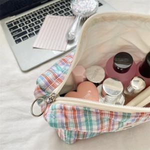 Flat lay of colorful plaid toiletry bag showing large capacity for makeup and skincare