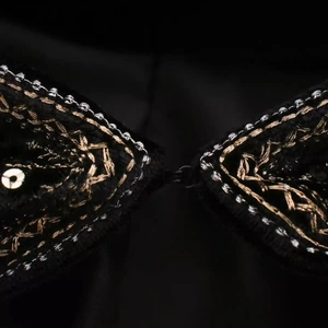 Haut élégant en velours de soie noir avec broderies dorées et argentées et crochets