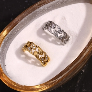Detailed view of intertwined Cuban link rings in gold and silver with pave diamonds