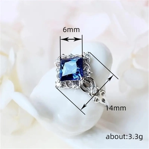 Macro shot of silver ring with blue sapphire zircon and intricate floral engraving