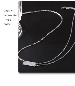 Detail of silver rectangular pendant engraved with 'Chudong' on a delicate titanium steel chain