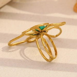 Detail of 18K gold-plated floral ring with hammered texture and green stone center
