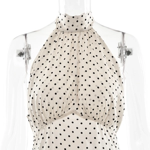 Gros plan détaillé d'une robe dos nu beige à pois noirs présentée sur un mannequin