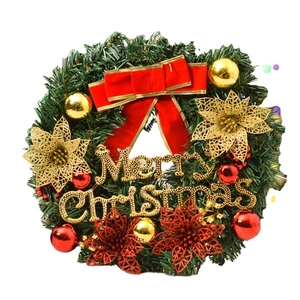 Christmas pine needle wreath with red bow, gold ornaments, and Merry Christmas sign