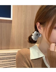Detail of grey plush koala hair clip worn on model's side hair for a cute look