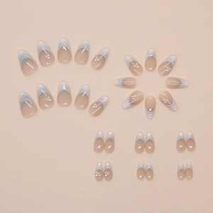 Macro detail of French almond press-on nails with white tips and pearl decorations
