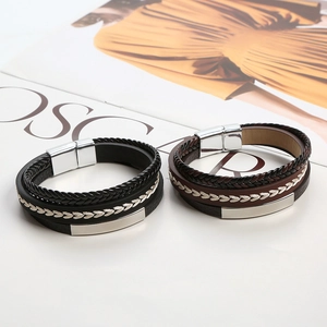 Close-up of black and brown braided leather bracelets with silver magnetic metal clasps