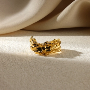 Detailed macro view of the irregular lava texture on the gold-plated geometric ring