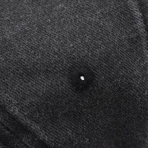 Macro shot of embroidered ventilation eyelet on charcoal washed cotton baseball cap fabric