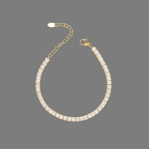Detailed close-up of golden square zircon bracelet with lobster clasp and adjustable chain