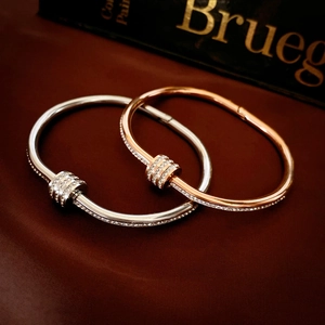 Detail of silver and rose gold steel bangles with sparkling pave diamond sliders