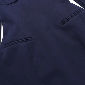 Detailed view of the dark blue woven fabric and precision stitching of the dual pocket design