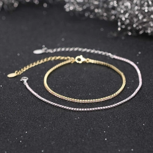 Macro detail of gold and silver tennis bracelets with pink zircons on black background