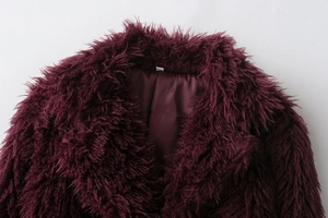 Detail of burgundy faux fur coat showing plush collar and smooth satin lining texture