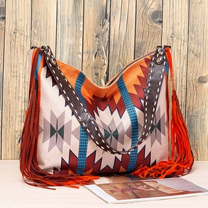 Detail of bohemian tote bag showing ethnic patterns, long tassels and leather shoulder strap