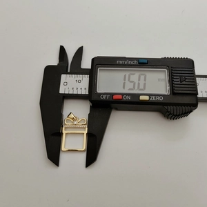 Macro view of gold gift box pendant measuring 15.0mm with electronic digital caliper