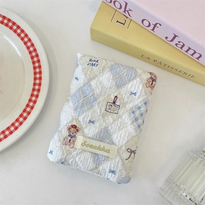 Quilted pouch with bear print and blue check pattern shown with coffee table decor