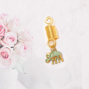 Macro shot of gold spiral dreadlock ring with a green enamel elephant charm pendant