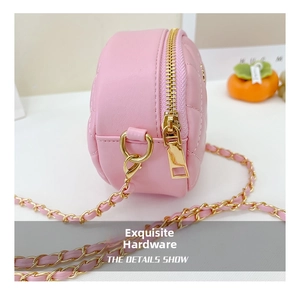 Detail view of pink quilted round mini bag featuring gold-tone zipper and chain strap