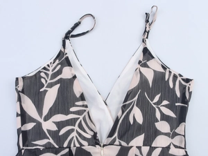 Detail view of the V-neckline and leaf print on the chiffon dress with a hidden zipper