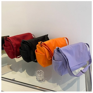 Detail view of colorful nylon messenger bags with side pockets and adjustable straps