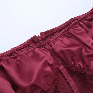 Vue macro détaillée des coutures en satin bordeaux et dentelle avec fermeture éclair invisible