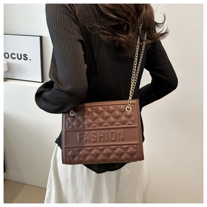 Detail of a brown quilted shoulder bag featuring gold chain and FASHION embossed strap
