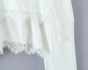 Vue macro d'un ourlet en dentelle blanche délicate et broderies sur tissu léger