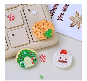 Close-up of resin Christmas charms featuring gingerbread man and Santa on a keyboard