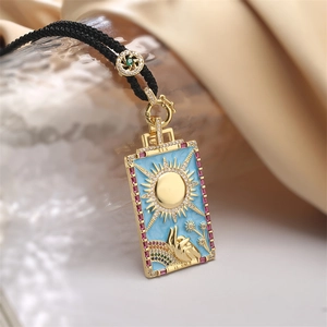 Dettaglio macro del ciondolo tarocchi sole con smalto azzurro e pietre preziose colorate