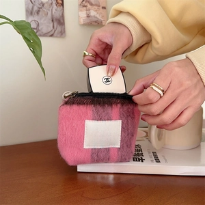 Macro shot of a mini plush striped cosmetic bag with a zipper for makeup storage